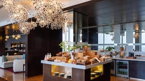 Een moderne keuken met een centraal eiland, ingebouwde apparatuur en een groot raam.