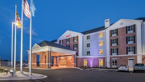 A hotel with a covered entrance, multiple floors, and a parking lot.