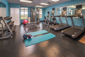 Ett gym med löpband, crosstrainers, hantlar och träningsbollar.