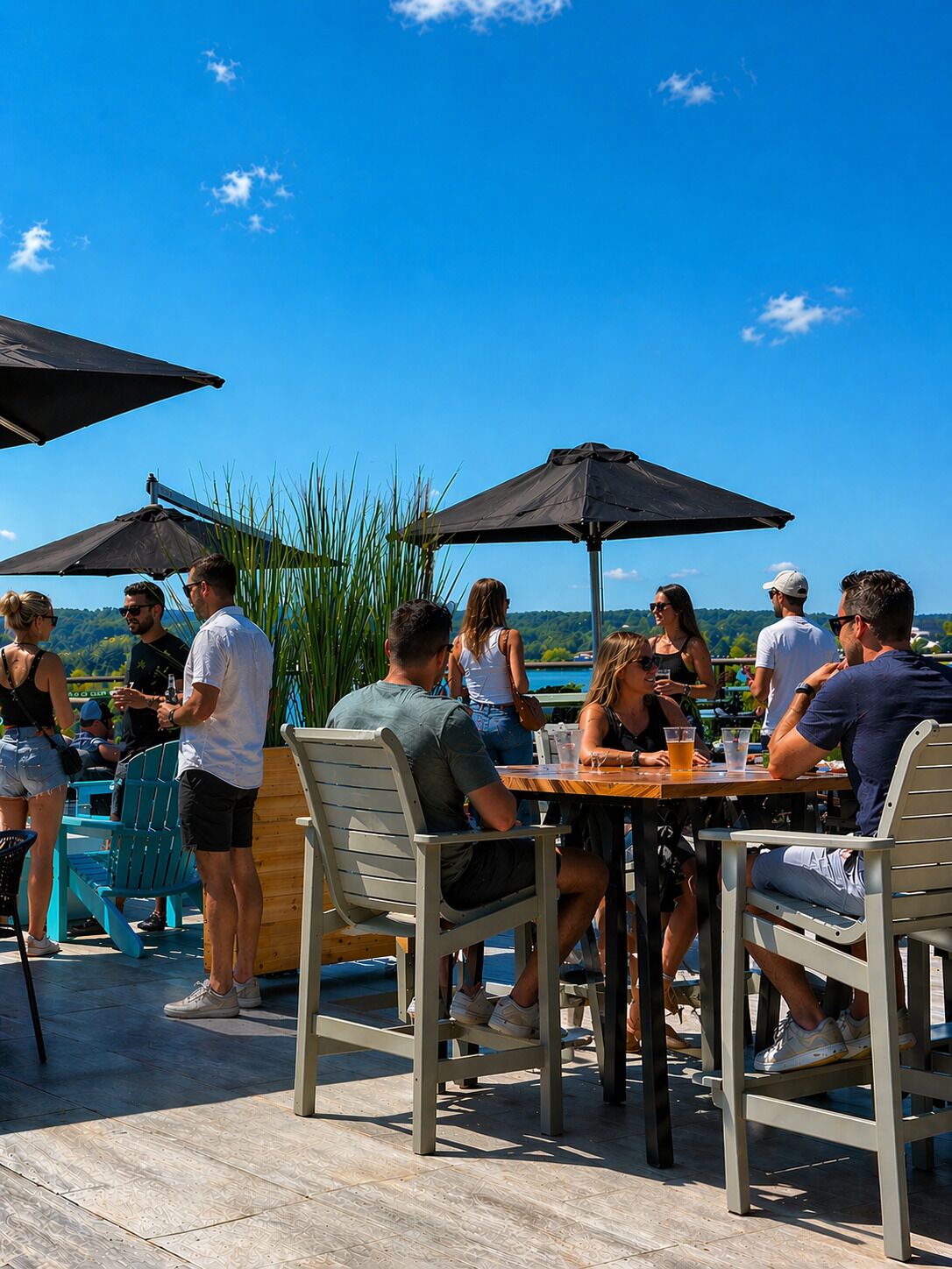 An outdoor dining area with tables and chairs, umbrellas, and a view of the landscape.