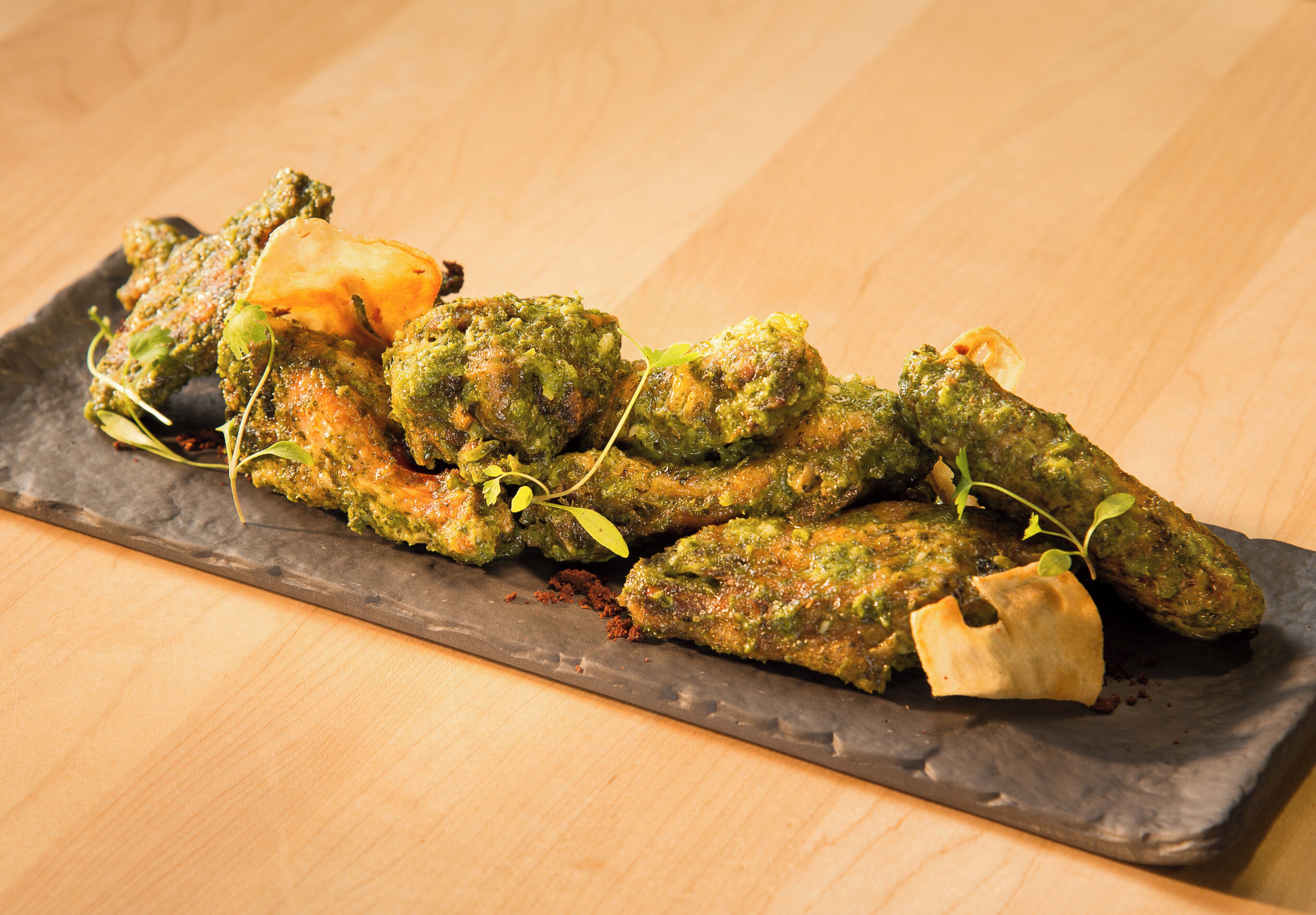 Ein Gericht mit frittiertem Okra auf einer Schieferplatte.