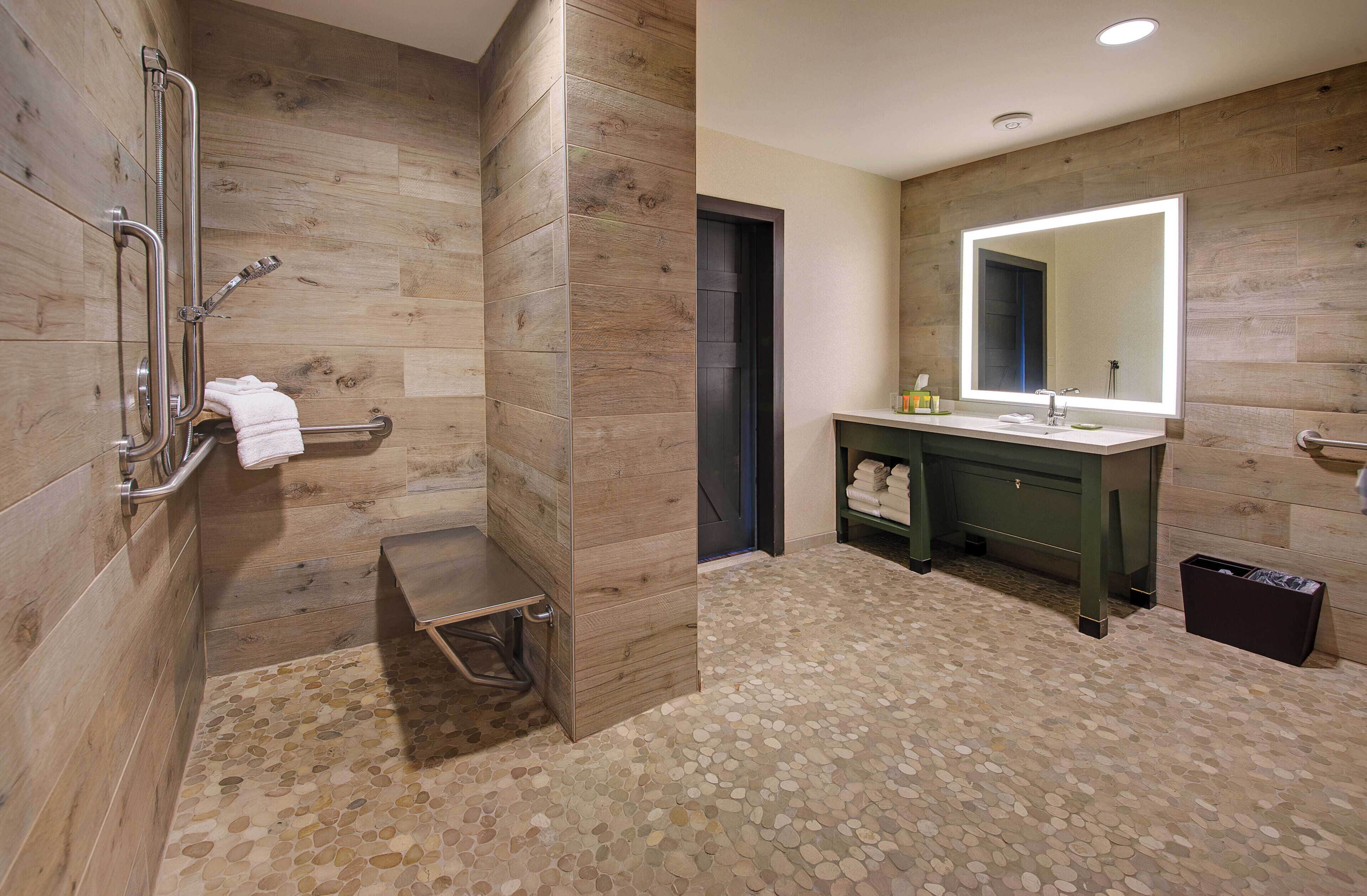 Une salle de bain moderne avec une douche, un lavabo et un grand miroir.