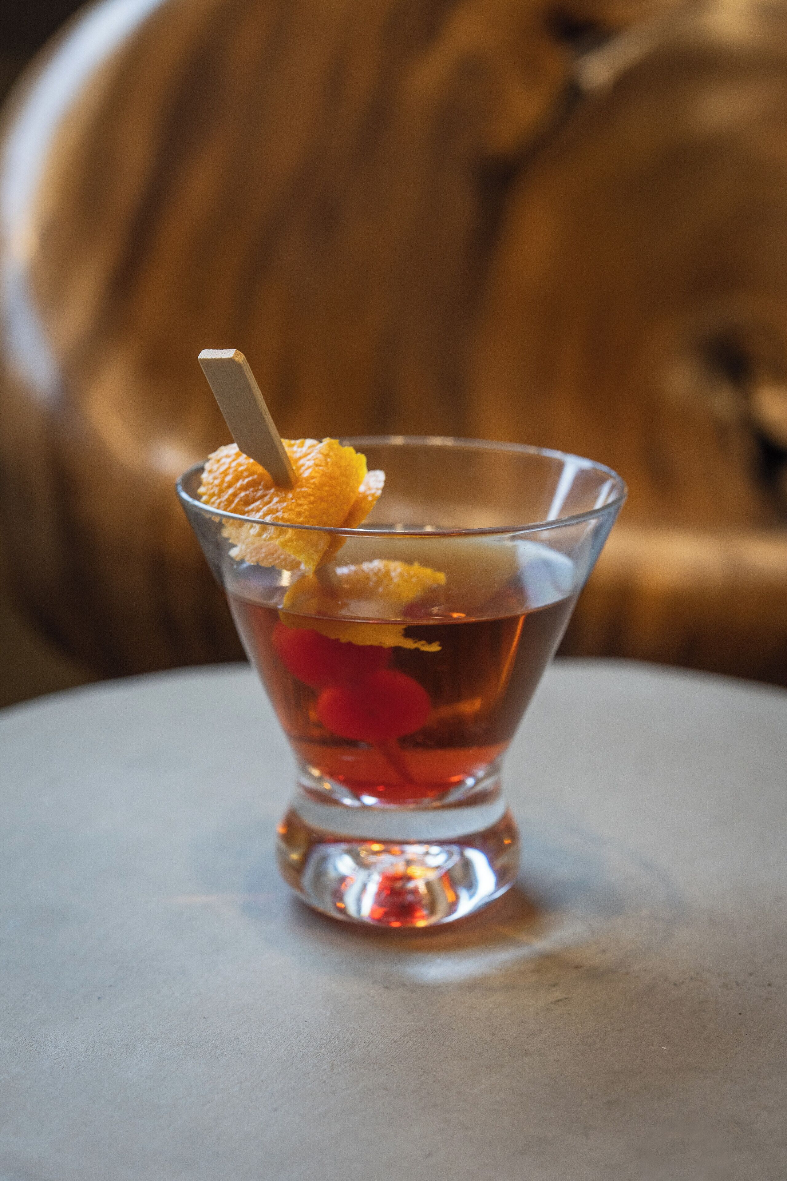A clear glass with a straw, containing a beverage and garnishes.