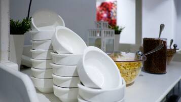 Un montón de tazones blancos y un tazón de cereal sobre una mesa blanca.