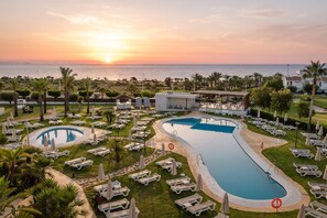 A resort with two swimming pools, sun loungers, and a view of the sunset over the sea. - ALEGRIA Palacio Mojacar - Adults Only (Mojacar)