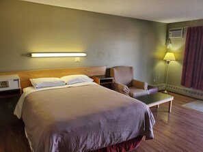 A hotel room with a bed, a chair, a desk, and a lamp. - Stars Inn & Suites Building B (Fort Saskatchewan)