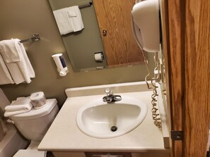 A bathroom with a toilet, sink, and towel rack. - Stars Inn & Suites Building B (Fort Saskatchewan)