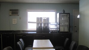 A kitchen with a window, cabinets, and a refrigerator. - Stars Inn & Suites Building B (Fort Saskatchewan)
