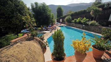 Una piscina al aire libre, sillones reclinables de piscina