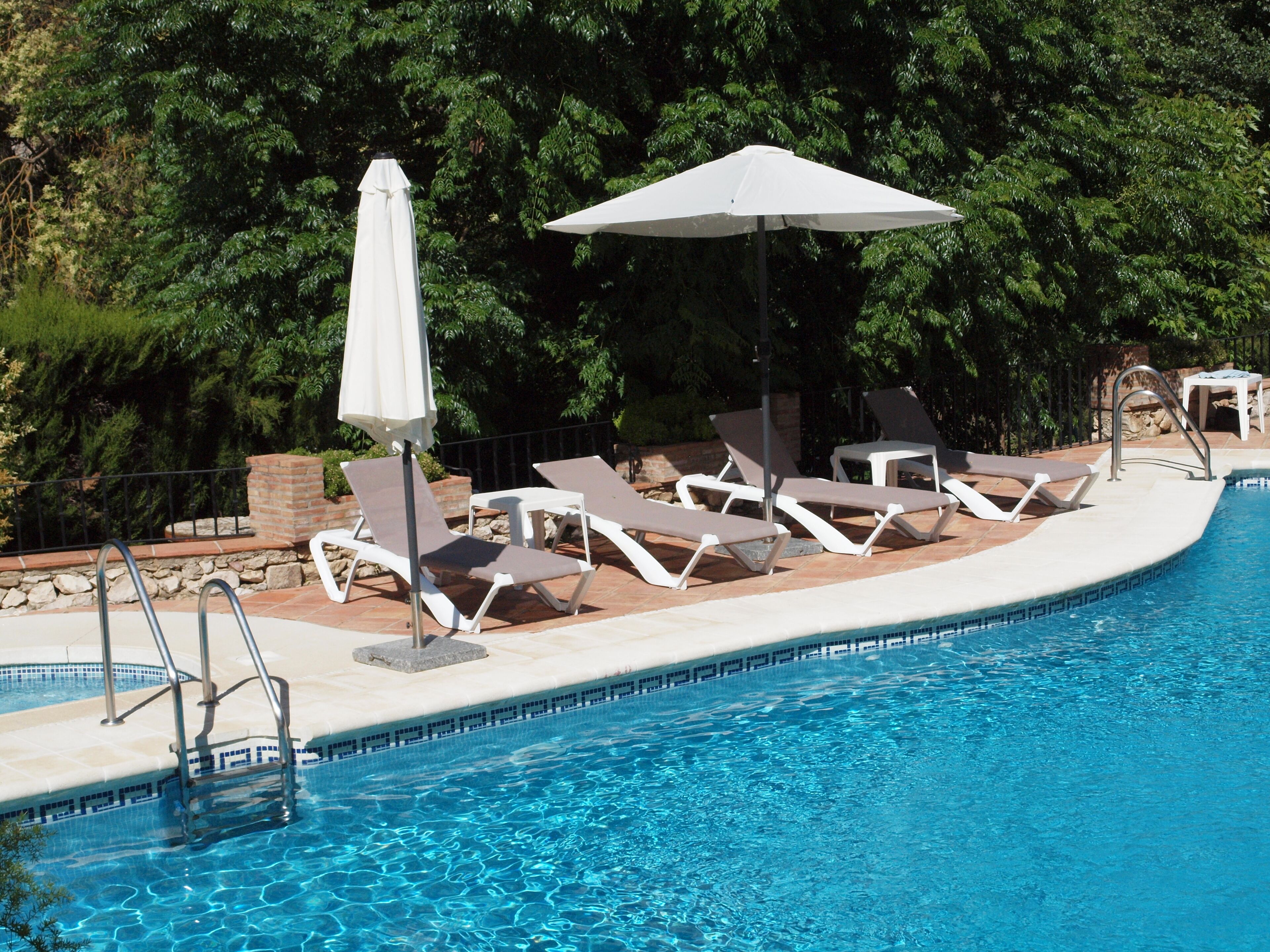 Una piscina al aire libre, tumbonas