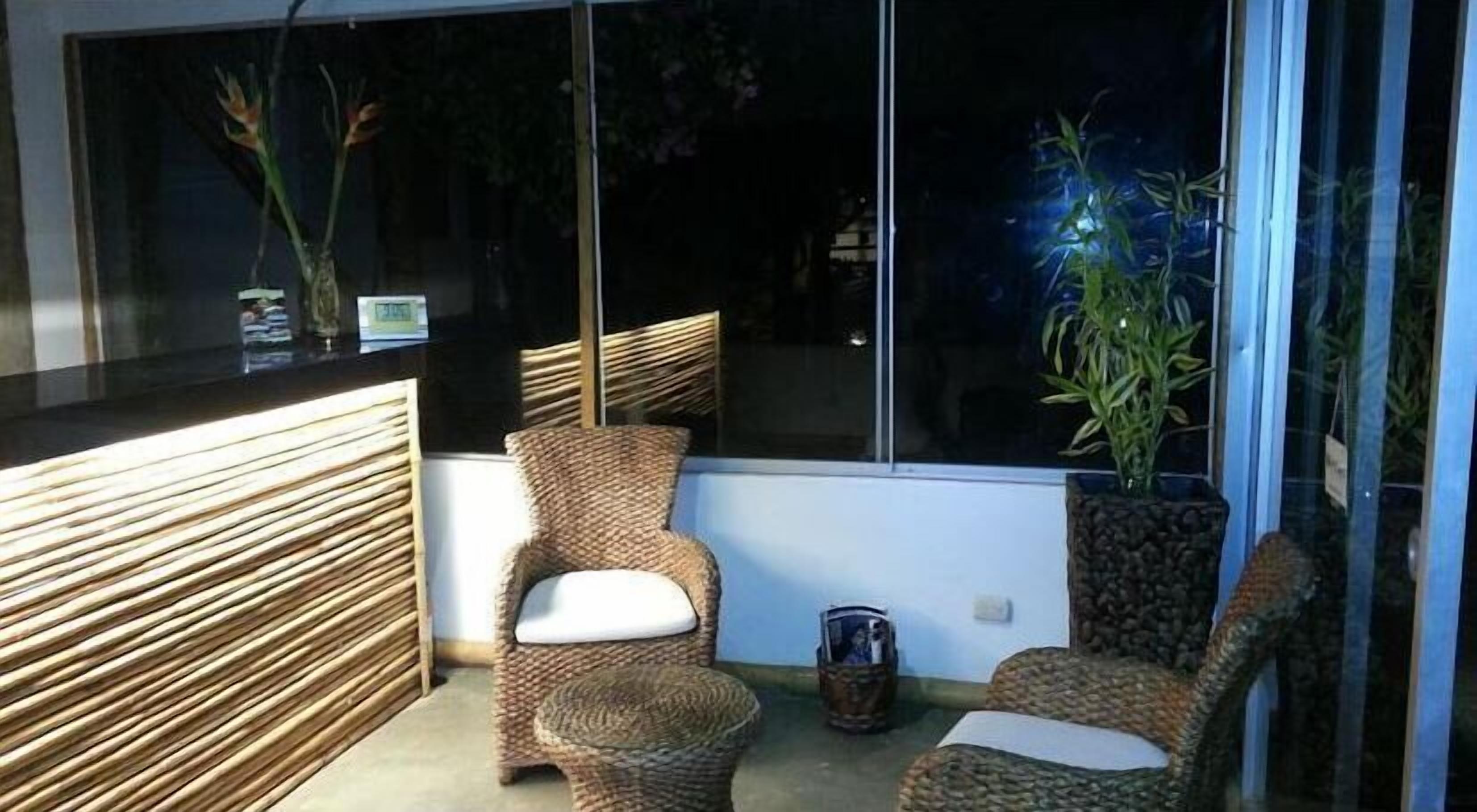 A modern room with wicker furniture, a large window, and a potted plant.