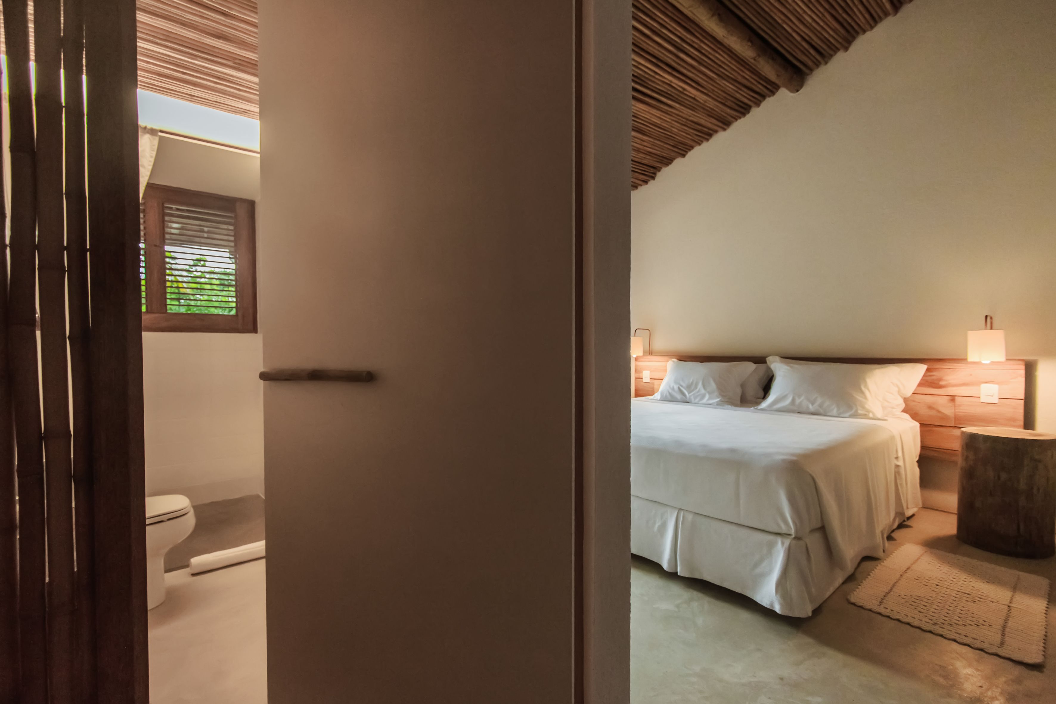 A bedroom with a bed, bedside tables, and a window.