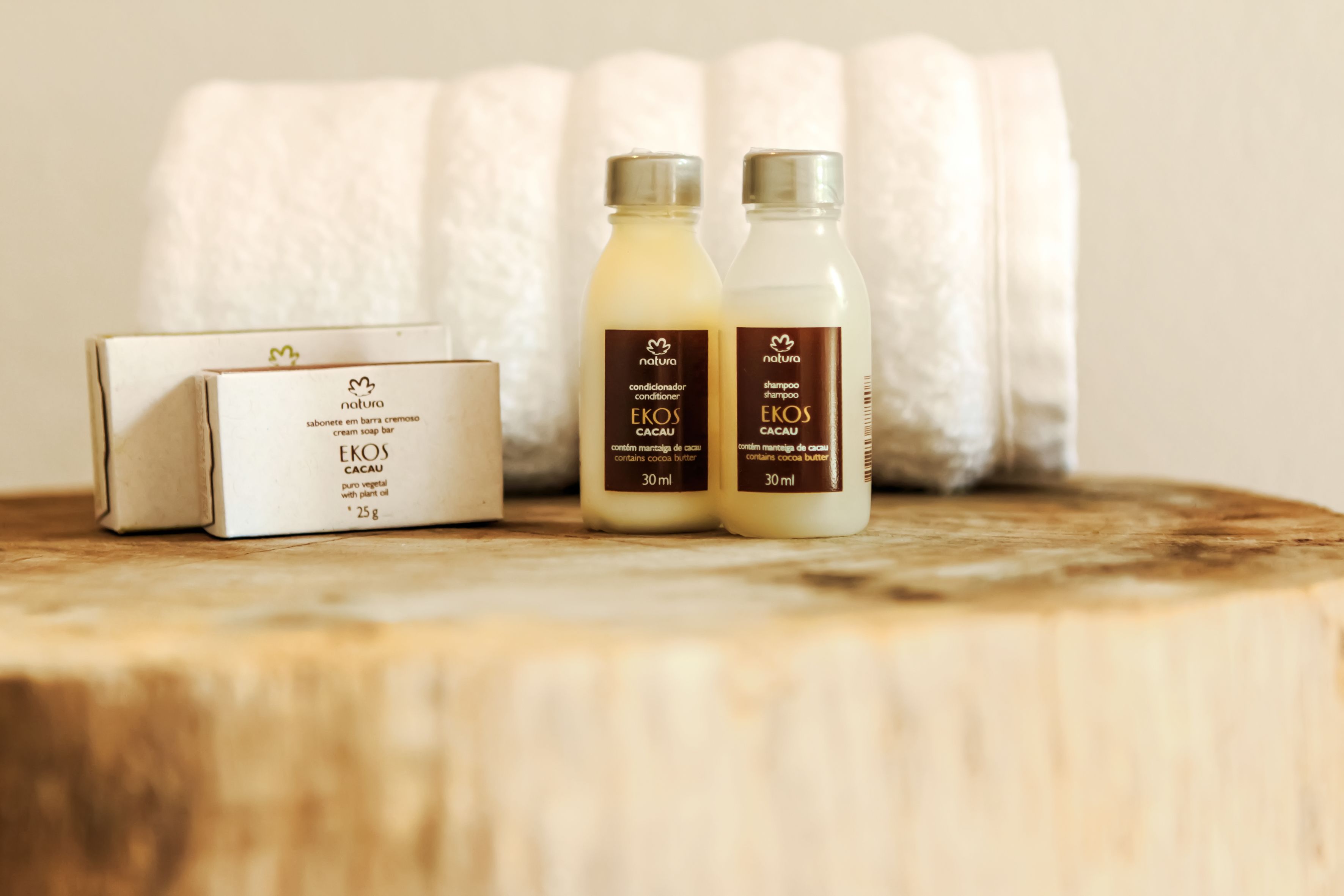 A wooden surface with two bottles of Natura skincare products and a box of Eros body wash.