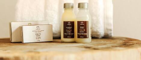A wooden surface with two bottles of Natura skincare products and a box of Eros body wash.
