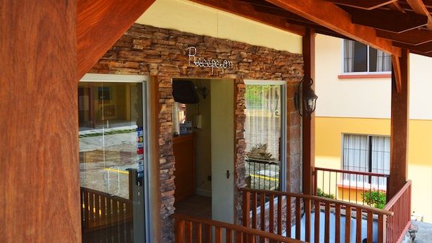 A stone facade with a wooden balcony railing and a sign above the entrance. - Hotel La Villa (Quesada)