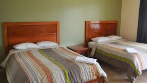 Two single beds with wooden headboards, a nightstand between them, and a plain wall. - Hotel La Villa (Quesada)
