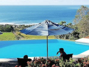 Outdoor pool, an infinity pool, pool umbrellas, pool loungers