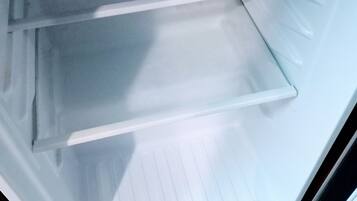 Un refrigerador abierto con tres estantes y un cajón para vegetales.