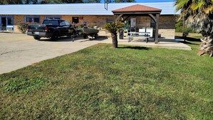A building with a brick facade, a covered picnic area, and a parked truck.