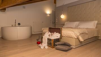 Een slaapkamer met een bed, een koffer, een rode kom en een witte badkuip.
