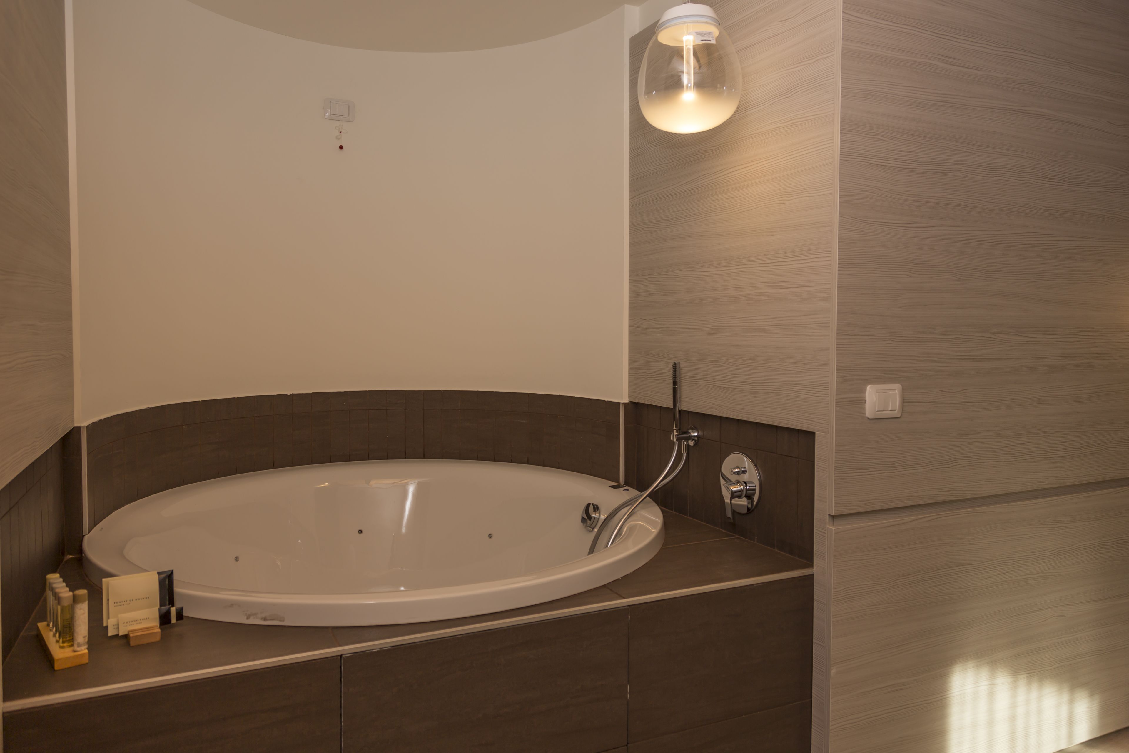 A modern bathroom with a freestanding bathtub, a wall-mounted light fixture, and a towel rack.