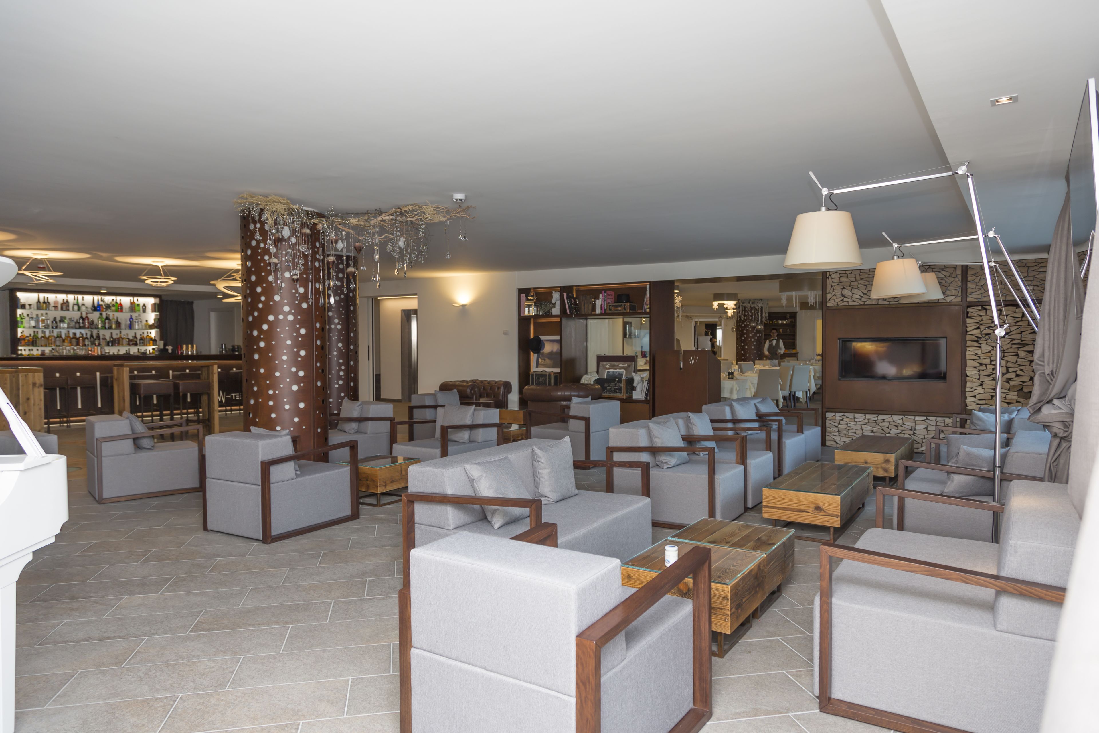 Una sala de estar moderna con varias zonas de estar, un bar y una chimenea.