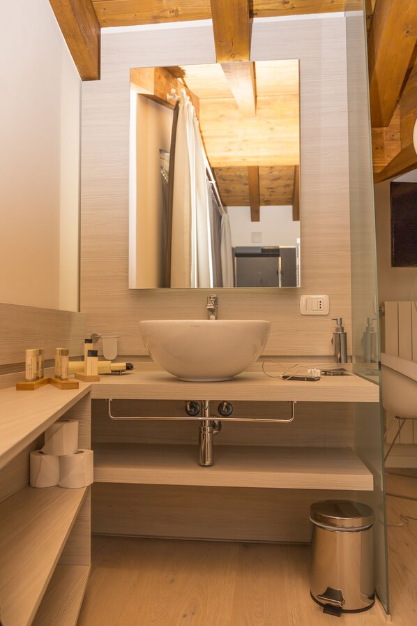 A modern bathroom with a large vessel sink, wooden vanity, and a glass shower enclosure. - White Angel Hotel (Valtournenche)