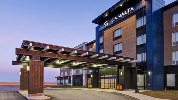 Ett modernt hotell med en tydlig skylt som visar namnet ”CANALITA”, en överbyggd entré och en väl upplyst fasad.
