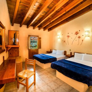 A hotel room with wooden beams, two beds, a desk, a chair, a mirror, and wall-mounted lights. - Posada Real del Valle (Valle de Bravo)