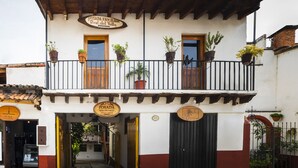 A two-story building with a balcony, potted plants, and a sign reading "POSADA FAMILIAR Real del Valle". - Posada Valle de Bravo (Valle de Bravo)