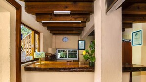 A kitchen area with wooden beams, a clock, a window, and a vase with flowers. - Posada Valle de Bravo (Valle de Bravo)
