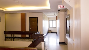 Ein Hotelkorridor mit einer hölzernen Bank, einem Feuerschutztürschild und einer Tür mit der Nummer 312.