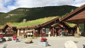 A rustic lodge with wooden cabins and a central building with a sign. - Saltdal Turistsenter - Campground (Saltdal)