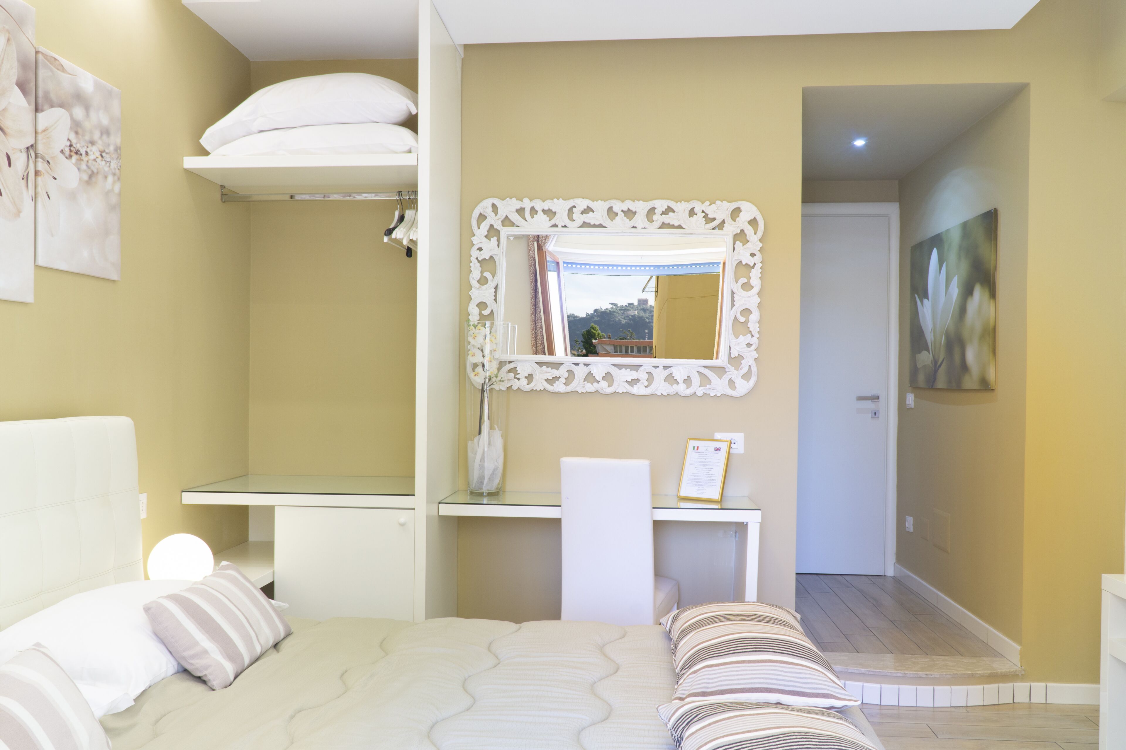 A bedroom with a bed, bedside table, and a mirror.