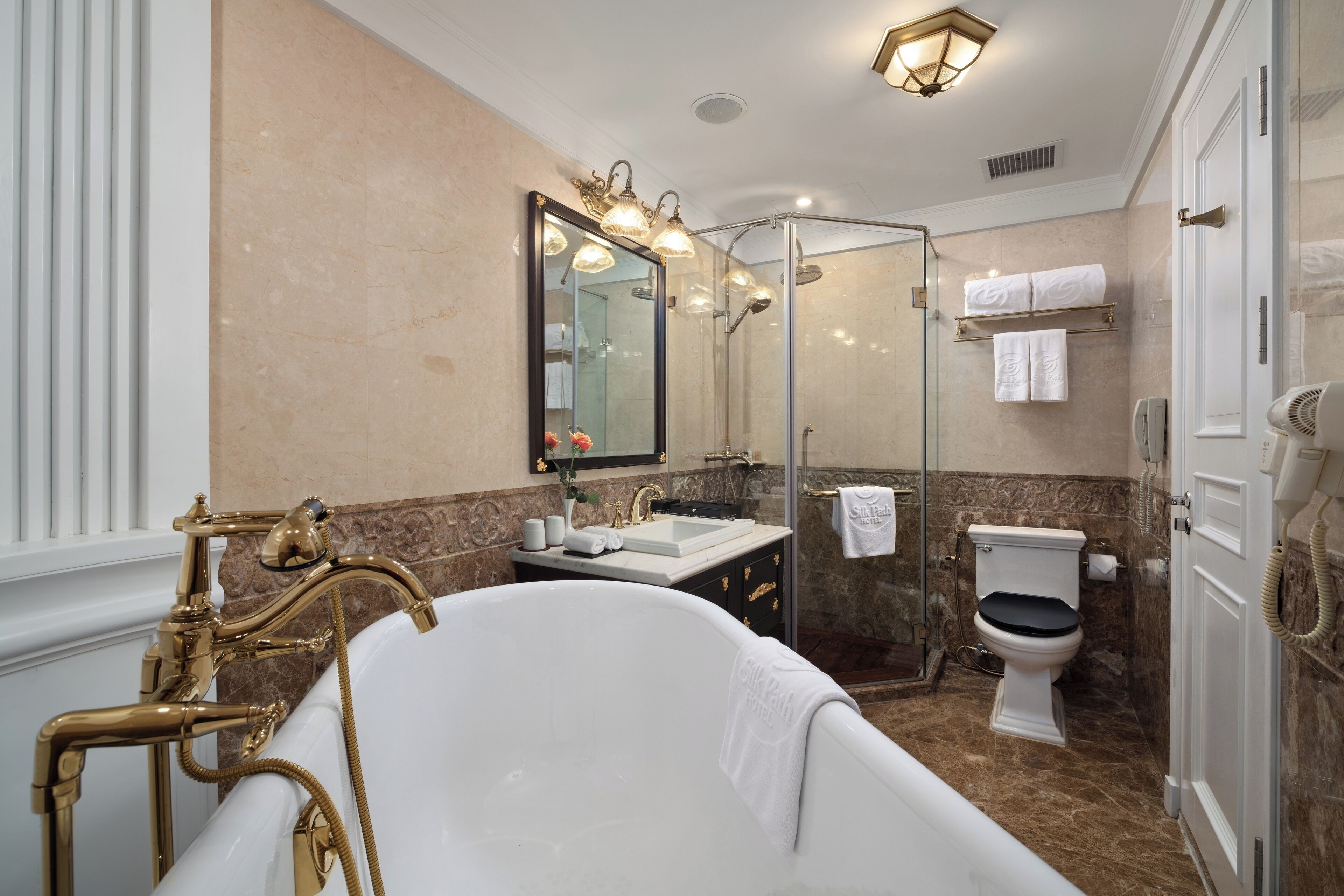 A bathroom with a freestanding bathtub, a glass-enclosed shower, a sink, and a toilet.