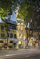 A historic building with a prominent balcony, a café, and a sign for 'Silk Boutique'.