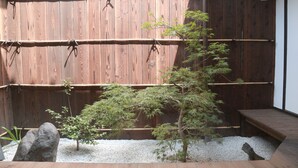 A wooden deck with a small tree and a rock. - Kyomachiya-Oyado Hana (Kyoto)