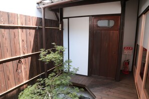 Fachada de madeira com porta de madeira e extintor fixado na parede.