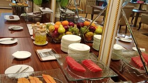 Un montaje tipo bufé con diversas frutas, verduras y postres.
