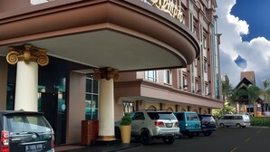 Un hotel con una entrada destacada, una fachada curva y un cielo despejado.