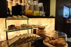 A breakfast buffet with pastries, sandwiches, and a coffee station. - Syama Suite Sukhumvit 20 (Bangkok)