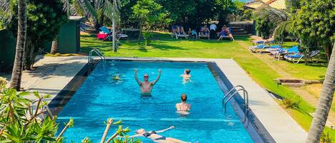 Una piscina al aire libre, camas de piscina gratis, sombrillas