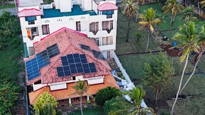 Um edifício com vários andares, piscina e painéis solares no telhado.