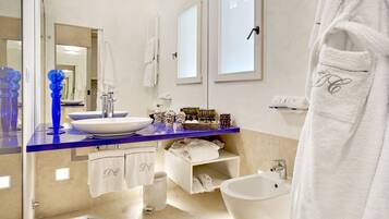 Un baño moderno con un lavabo blanco, una encimera azul y una bañera blanca.