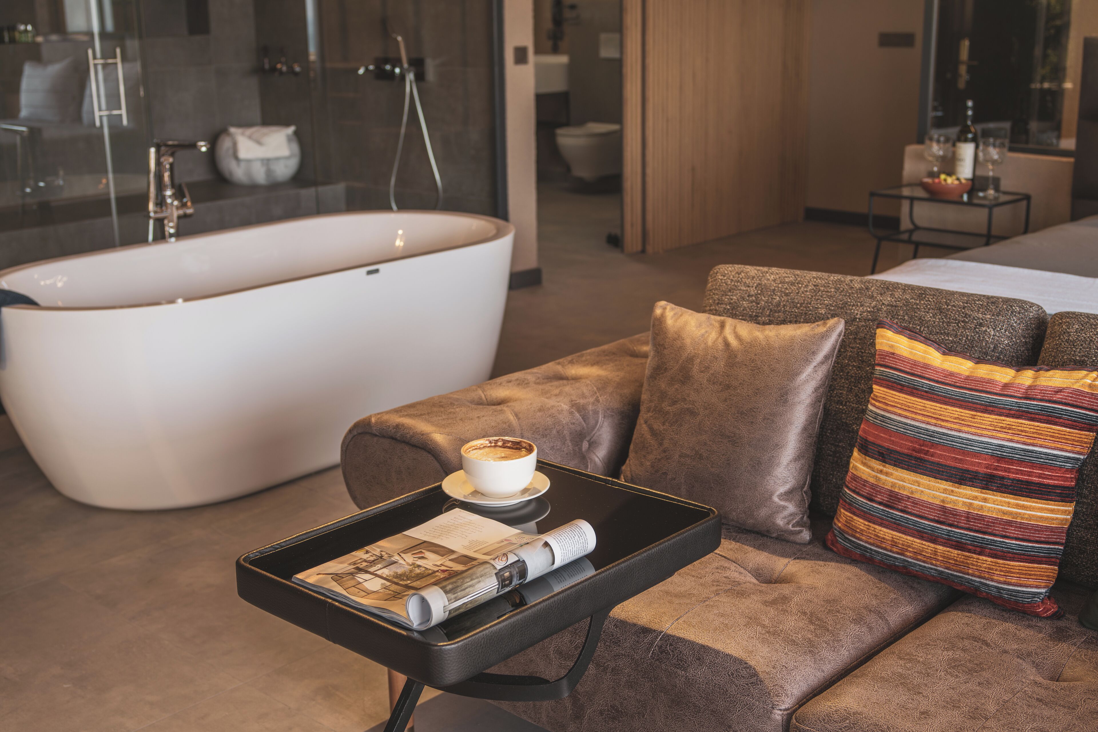 A modern bathroom with a freestanding bathtub, a glass shower enclosure, and a visible toilet in the background.