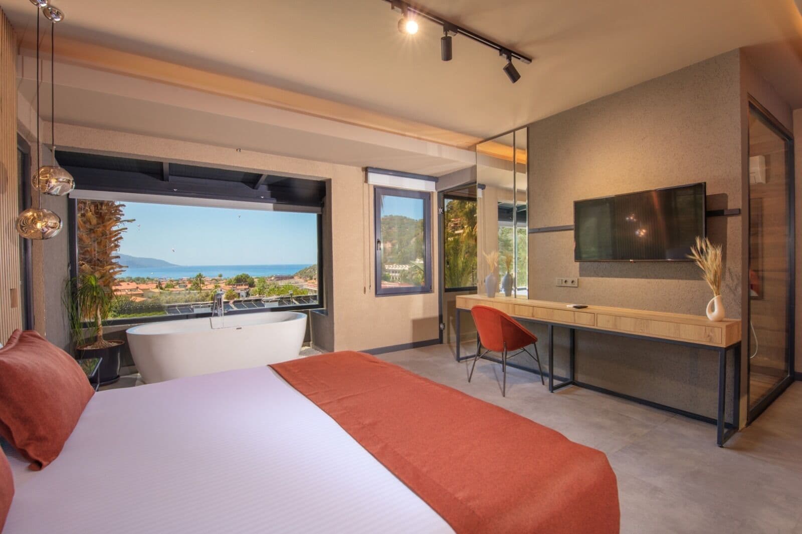 Ein modernes Schlafzimmer mit einem großen Bett, einem Schreibtisch und einer Badewanne.
