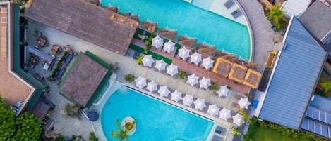 Una piscina al aire libre, sombrillas, tumbonas