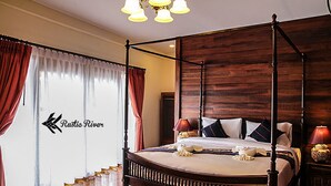 A four-poster bed with a wooden headboard, a large window with sheer curtains, and a chandelier. - Rustic River Boutique (Chiang Mai)