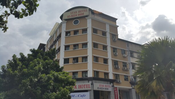 A multi-story hotel with a beige facade, multiple balconies, and air conditioning units. - First and New Star Hotel (Kuala Lumpur)