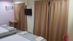 A hotel room with two beds, a small table, a TV mounted on the wall, and a curtain. - First and New Star Hotel (Kuala Lumpur)